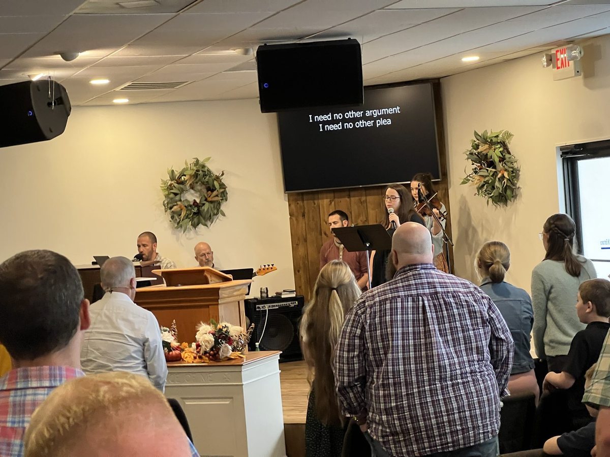 Church members standing and talking together in the sanctuary after a service