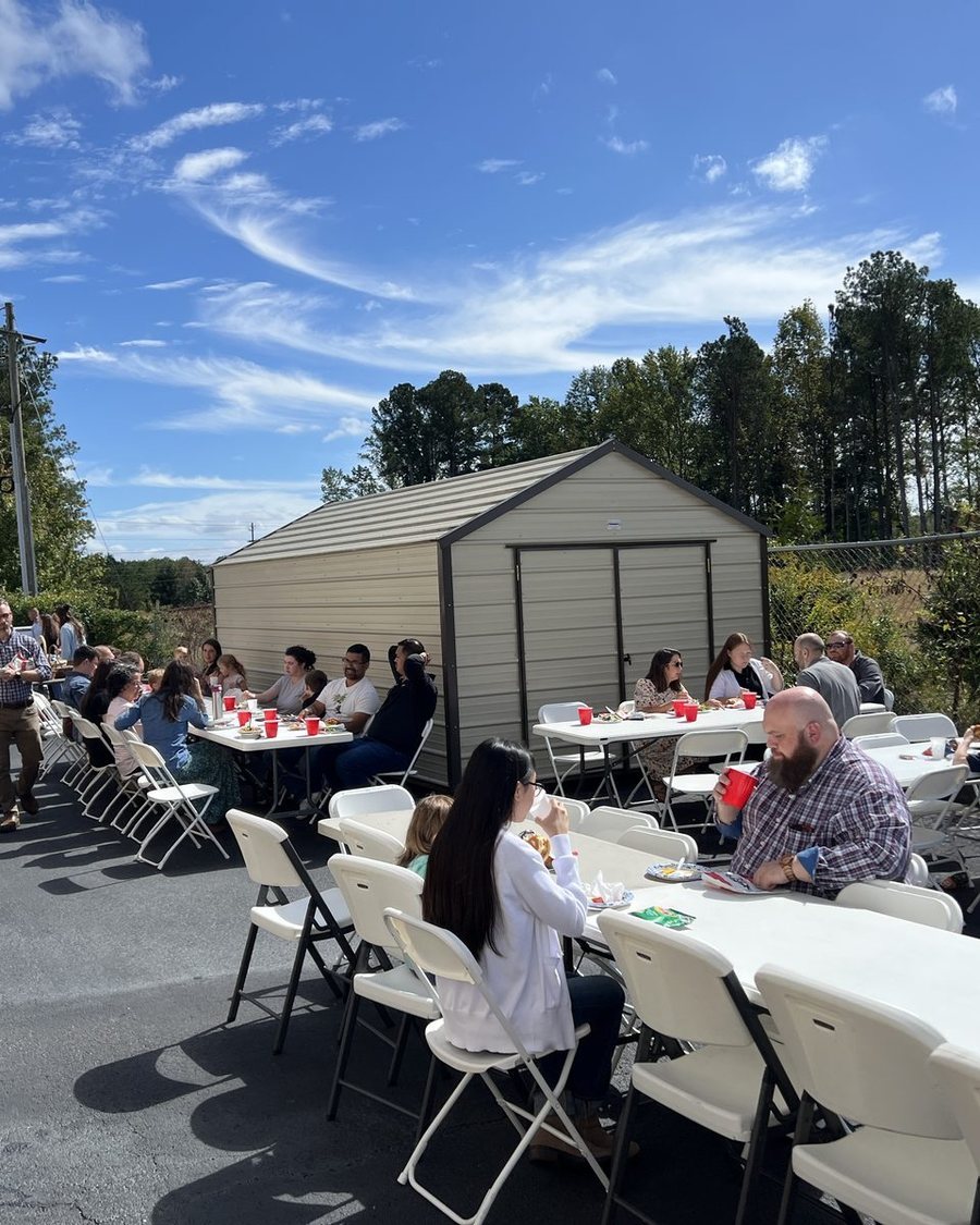 Church families eating together at long tables outdoors